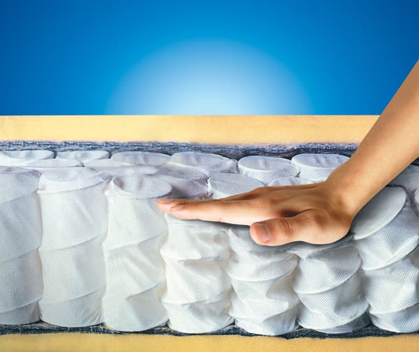 iStock Credit: WhiteJack A person pressing down on mattress coils